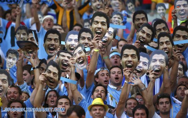 Aficionados portan máscara con imagen de Luis Suárez