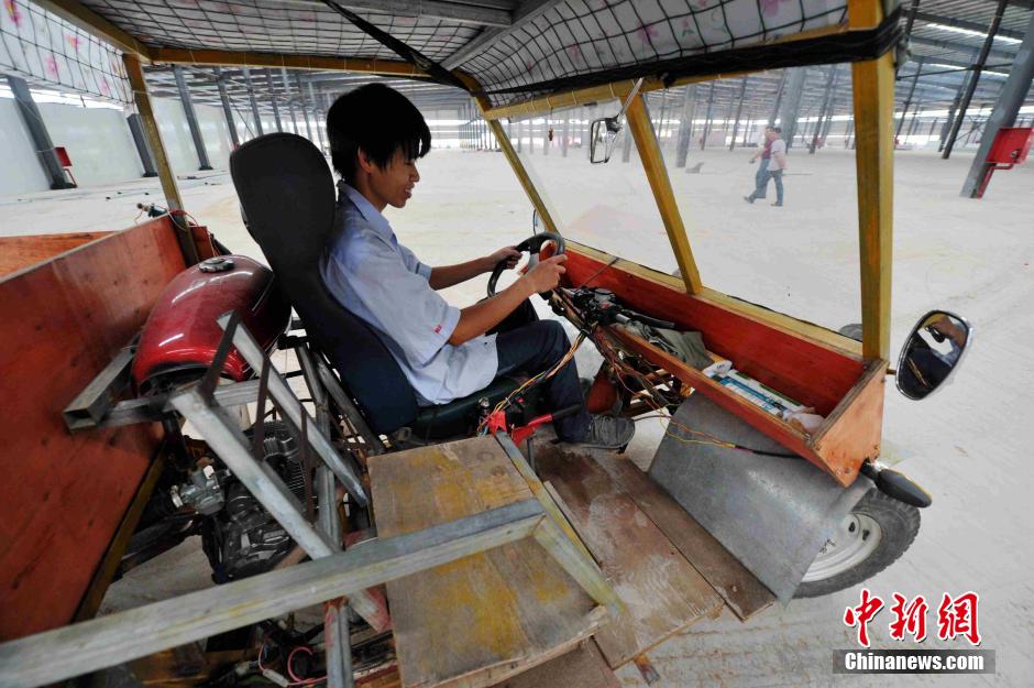 El joven inventor conduce su singular automóvil.