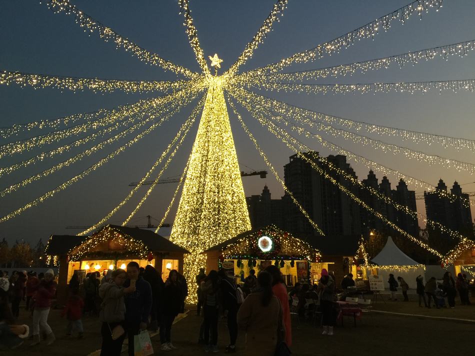 El mercado navide?o alemán en el distrito Xuhui de Shanghai es el mayor mercado de Navidad de China. Cuenta con un árbol de Navidad de 16 metros de altura adornado con más de 20.000 luces brillantes y actuaciones en directo de coros, cantantes de pop y DJs. [Foto / CRI ]