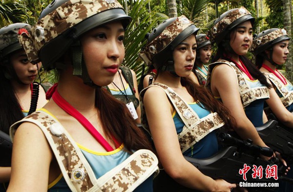 Las candidatas "Miss?Leisure?2014",?camuflajeadas?y?sosteniendo?armas?láser,?juegan?al Counter-Strike en Hainan. [Foto: Chinanews.com] 