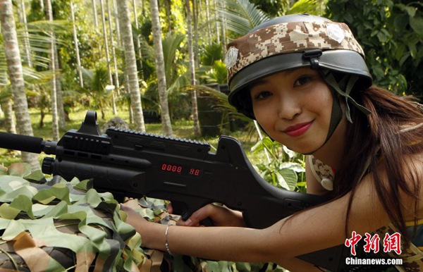 Las candidatas "Miss?Leisure?2014",?camuflajeadas?y?sosteniendo?armas?láser,?juegan?al Counter-Strike en Hainan. [Foto: Chinanews.com]