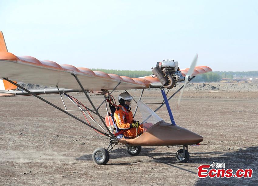 Yang Shijun se prepara para hacer volar su avión peque?o de fabricación casera hasta una altura de 200 metros en la ciudad de Changchun, provincia de Jilin, el 10 de mayo de 2015. Yang, de 45 a?os, ha realizado dos vuelos de prueba en el pasado y ha logrado volar durante 2,5 horas. Yang dice que el avión se llamará como su padre, Jinhai. El ingenioso planea construir tres aviones biplaza en el futuro. [Foto/ECNS]