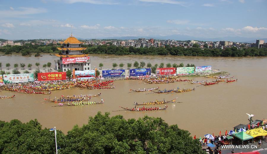 Los competidores reman en los barcos de dragón durante una carrera celebrada en el río Xiaoshuihe para celebrar el Festival del Barco de Dragón en Yongzhou, provincia de Hunan, el 16 de junio de 2015. [Foto/Xinhua]