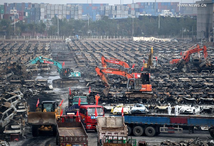 El servicio de rescate y varias máquinas retiran los vehículos calcinados tras la explosión de Tianjin, el 20 de agosto. [Foto/Xinhua]