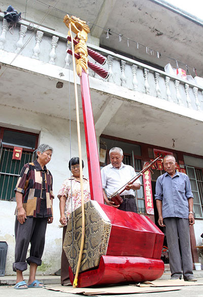 Ji Jiarong (el hombre de blanco), de 74 a?os, muestra un erhu gigante que él mismo fabricó en la aldea Liuji de Baidian, condado Haian, provincia de Jiangsu, el 21 de agosto de 2015.