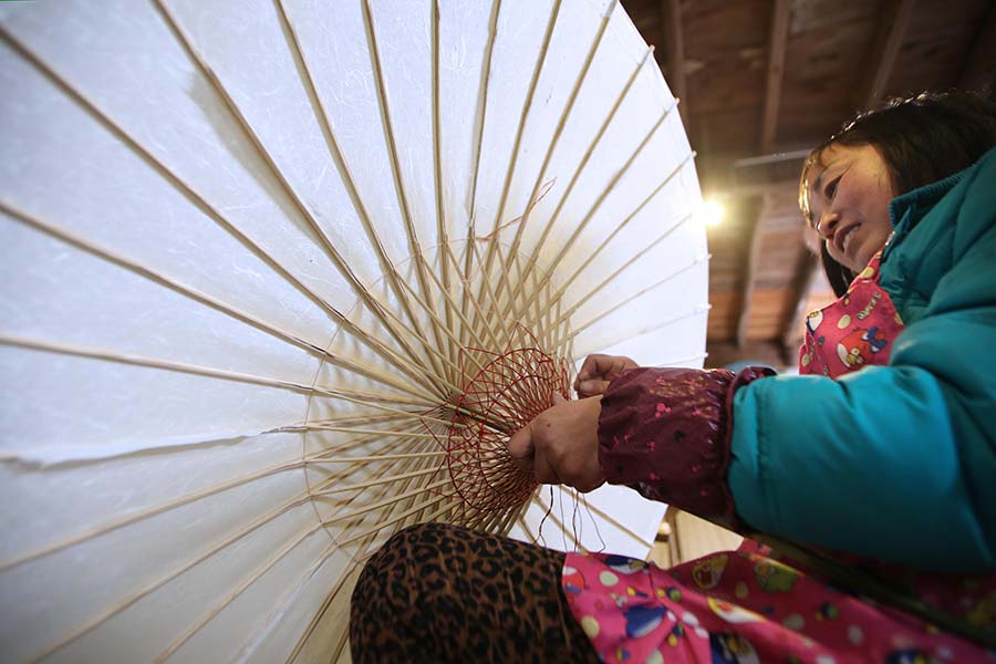 Una mujer fabrica una sombrilla de papel de Yuhang en la aldea de Tangbu, distrito de Yuhang en Hangzhou, provincia de Zhejiang. 