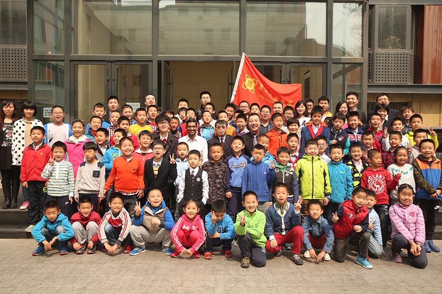 El presidente ejecutivo de Google, Sundar Pichai, se hace una foto en grupo con los ni?os de la Escuela Go Nie Weiping en Beijing, el 31 de marzo de 2016. [Foto de China Daily]