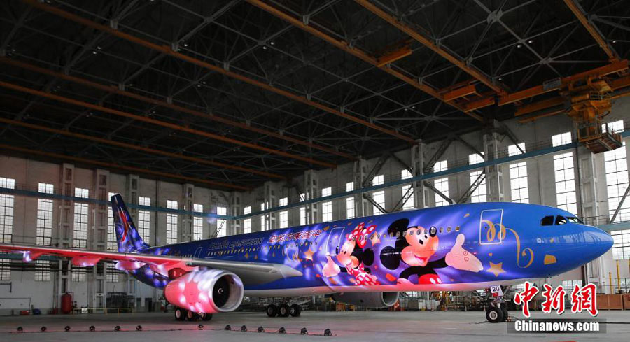 Un avión con temática de Shanghai Disney ha hecho su primera aparición en Shanghai el 25 de abril de 2016. El avión, operado por China Eastern Airlines, está pintado de azul con dos figuras gigantes de Mickey y Minnie Mouse. Más aviones con temática de Disney divertirán en un futuro próximo a los visitantes que lleguen a la ciudad. El parque temático Disneyland Shanghai abrirá sus puertas el 16 de junio. [Foto/Chinanews.com]