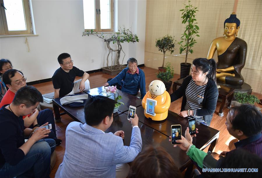 BEIJING, mayo 8, 2016 (Xinhua) -- Imagen del 22 de abril de 2016 muestra que los visitantes conversaban con el Monje Xian'er, un personaje de caricaturas del Monasterio Longquan, en el monasterio en Beijing, capital de China. El Monje Xian'er es un popular personaje de caricaturas creado por el maestro Xianfan para responder acertijos introspectivos de los visitantes y traerles la paz. El Monasterio Longquan está localizado al pie de la Monta?a Fenghuangling (Phoenix Ridge), en las afueras occidentales de Beijing. Primero construido en la Dinastía Liao 907-1125), el monasterio recupera la reputación al acoger la era del internet móvil. (Xinhua/Luo Xiaoguang) 