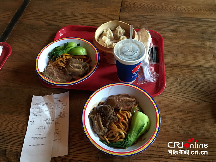 Foto del 20 de mayo de 2016 muestra dos tazones de fideos, una Coca Cola y una cesta de bollos rellenos de cerdo, que cuesta en total 180 yuanes (28 dólares). [Foto: CRIONLINE.com]