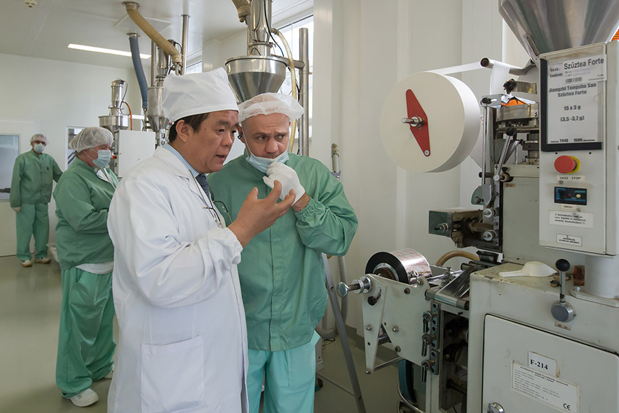 Chen Zhen habla con un empleado en su empresa de medicina tradicional china de Budapest, capital de Hungría, el 19 de mayo de 2016. [Foto/Xinhua]