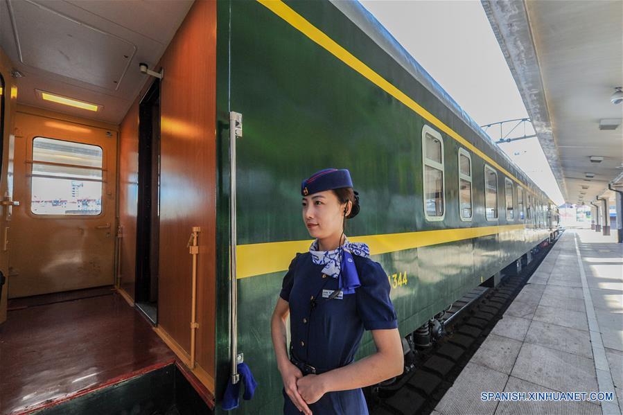 HELONGJIANG, mayo 31, 2016 (Xinhua) -- Una conductora espera a la entrada de un vagón de un tren turístico que corre de Harbin a Heihe, provincia de Helongjiang, en el noroeste de China, el 31 de mayo de 2016. Para satisfacer las necesidades de los turistas, la administración del ferrocarril de Heilongjiang abrió una nueva línea turística de Harbin a Heihe e invitó el martes a algunas personas a experimentar la línea. (Xinhua/Wang Song)