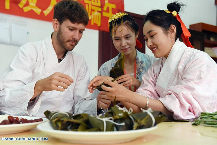 Matthew (i) de Estados Unidos de América, aprende a elaborar Zongzi, una bola de masa de arroz glutinoso envuelta en holas de bambú u hojas rojas, con motivo del próximo Festival del Bote de Dragón o Duanwu en chino, en Cangzhou, provincia de Hebei, en el norte de China, el 8 de junio de 2016. El Duanwu se celebrará el 9 de junio este a?o. (Xinhua/Fu Xinchun)