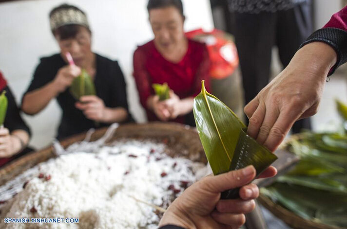 Personas elaboran Zongzi, arroz glutinozo colocado en hojas de bambú, para marcar el próximo Festival del Bote del Dragón, en el condado Zigui, capital de la provincia central de Hubei, China, el 8 de junio de 2016. El Festival del Bote de Dragón o "Duanwu" en chino, se celebra el quinto día del quinto mes del calendario lunar, celebrándose este a?o el 9 de junio. (Xinhua/Xiao Yijiu)