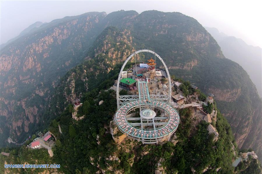 Personas practican yoga en una plataforma de cristal en Beijing