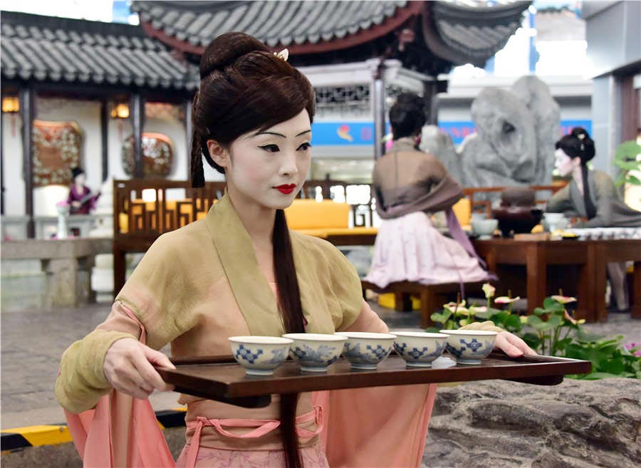 Una actriz en traje clásico sirve té durante el espectáculo de arte digital Night Revels of Han Xizai del Aeropuerto Internacional de Beijing, el 21 de junio de 2016. 