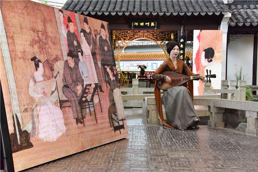 Una actriz en traje clásico toca un instrumento durante el espectáculo de arte digital Night Revels of Han Xizai del Aeropuerto Internacional de Beijing, el 21 de junio de 2016. 