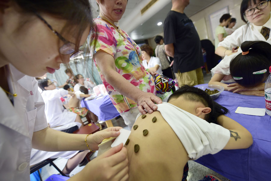 Beijing,13/07/2016 (El Pueblo en Línea)-Un?médico?aplica?una?especie?de?pasta?en la espalda de un ni?o hecha con?medicina?tradicional?china?para?los días de más calor, en Hangzhou, provincia?de?Zhejiang, el 13 de julio de?2016.?La?pasta?para el alivio del calor es?muy?popular?y?se?supone que ayuda a?curar?algunas?enfermedades?que se producen?sobre todo?en?invierno.?[Foto/VCG]