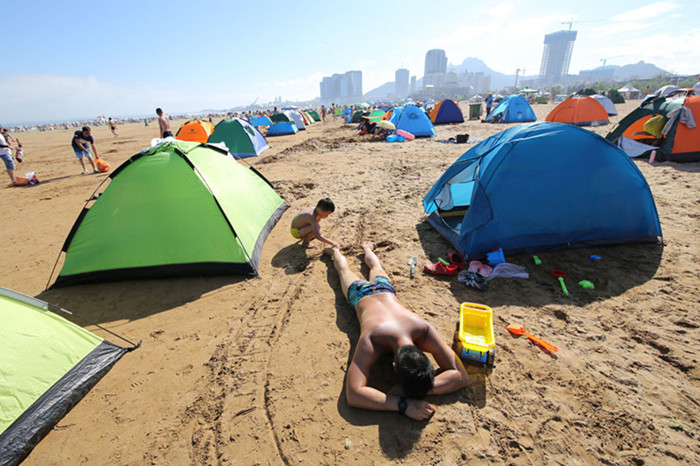 Los turistas ponen tiendas de campa?a en una playa de Qionghai en Hainan, el 10 de julio de 2016. [Foto/VCG]