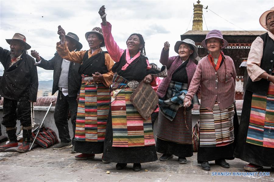 Residentes lanzan tsampa, un alimento horneado hecho de harina de cebada, durante el evento del descubrimiento del Buda en el monasterio Zhaxi Lhunbo, en Xigaze, en la región autónoma del Tíbet, en el suroeste de China, el 20 de julio de 2016. La ceremonia anual concluyó el miércoles. (Xinhua/Zheng Huansong)