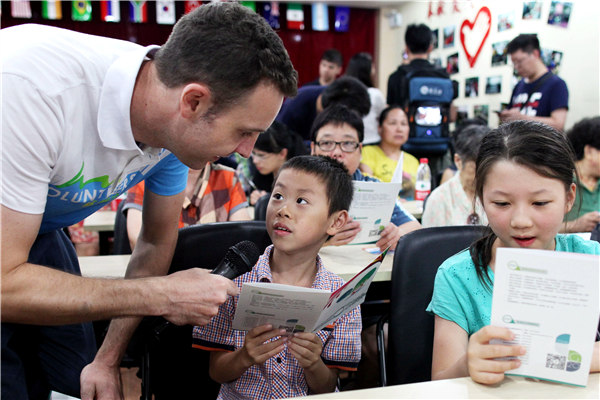 Timothy Clancy, estudiante australiano en la Universidad de Zhejiang, ense?a inglés a los ni?os como voluntario para la próxima Cumbre del G20 en Hangzhou. XINGXIN ZHU / CHINA DAILY