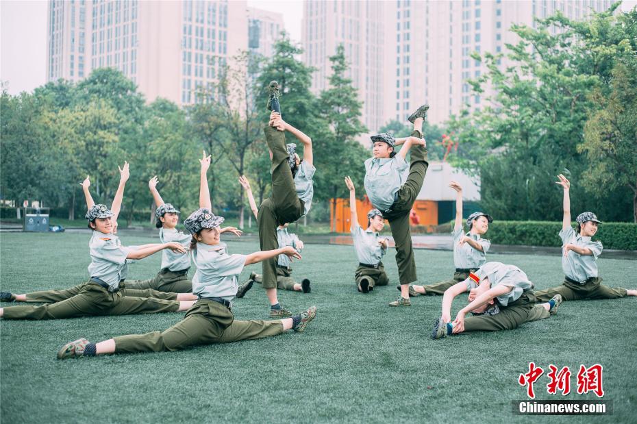 Las estudiantes de danzade la Universidad de Chongqing bailan en los descansos del entrenamiento militar