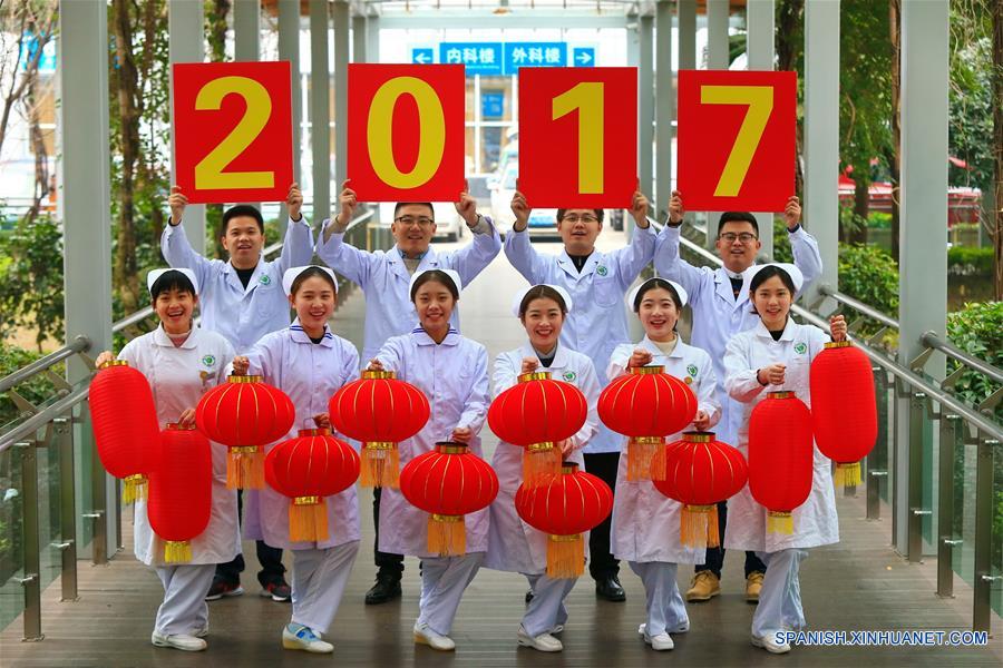 Trabajadores médicos sosteniendo linternas rojas y signos escritos con la leyenda del "2017" posan para saludar el próximo A?o Nuevo, en la ciudad de Suining, provincia de Sichuan, en el suroeste de China, el 31 de diciembre de 2016. (Xinhua/Zhong Min)