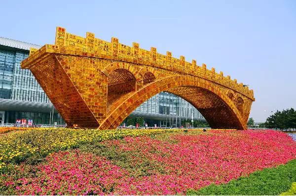 Frente a la plaza del Centro Nacional de Conferencias se ha instalado un parterre con forma de ¨puente de oro¨ que atrae las miradas de los participantes. Este parterre temático simboliza un puente de conexión, diálogo, desarrollo pacífico y beneficio mutuo, que conecta a China con el mundo.