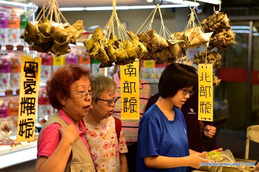 TAIPEI, mayo 29, 2017 (Xinhua) -- Personas compran "zongzi", dumplings con forma de pirámide elaborados con arroz glutinoso, envueltos en hojas de bambú o ca?a, en un mercado en Taipei, Taiwan, en el sureste de China, el 29 de mayo de 2017. (Xinhua/Liu Junxi)