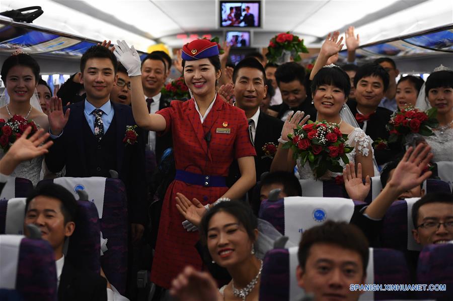 GANSU, julio 9, 2017 (Xinhua) -- El conductor de tren Li Jia, posa para una fotografía grupal con un grupo de parejas recién casados sobre el tren bala G2028 en la Estación Ferroviaria Lanzhou Oeste en Lanzhou, en la provincia Gansu, en el noroeste de China, el 9 de julio de 2017. Una nueva línea ferroviaria de alta velocidad que enlaza la ciudad de Baoji, en la provincia noroccidental china de Shaanxi, con Lanzhou, capital de la provincia vecina de Gansu, entró en operación el domingo. Gracias a esta nueva línea, las provincias de Gansu y Qinghai, así como la región autónoma uygur de Xinjiang, todas ubicadas en el noroeste de China, se han unido a la red nacional de ferrocarriles de alta velocidad. (Xinhua/Chen Bin)