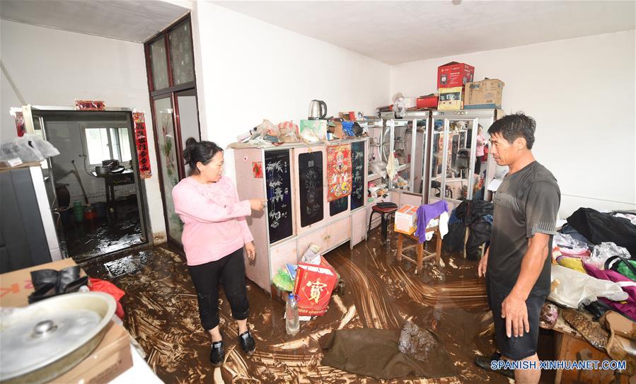 Residentes limpian su vivienda en la aldea Daheyan, en el condado de Xiuyan de Anshan, en la provincia de Liaoning, en el noreste de China, el 4 de agosto de 2017. Una lluvia torrencial afectó al condado el jueves y viernes, da?ando caminos, instalaciones de electricidad y cultivos en algunos municipios. Un total de 18,900 personas han sido trasladadas a lugares seguros, y la ciudad ha iniciado el nivel 1 de respuesta de emergencias para enfrentar las posibles inundaciones. (Xinhua/Yang Qing)