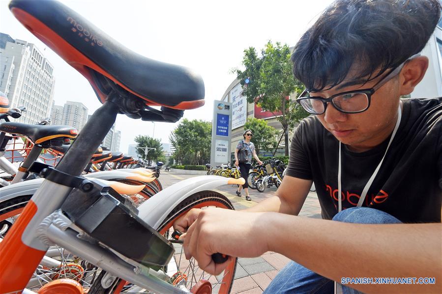 TIANJIN, agosto 21, 2017 (Xinhua) -- Un despachador de bicicletas compartidas repara una bicicleta da?ada en Tianjin, en el norte de China, el 21 de agosto de 2017. A pesar del clima sofocante en Tianjin, los despachadores, que también son trabajadores de mantenimiento, viajan por la ciudad para asegurar que las biciclets estén en orden y funcionen bien. (Xinhua/Shi Songyu) 