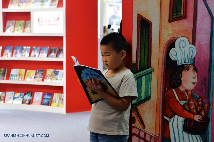 Un ni?o lee un libro durante la 24 Feria Internacional del Libro de Beijing llevada a cabo en la Nueva Sede del Centro Internacional de Exposiciones de China, en Beijing, capital de China, el 23 de agosto de 2017. (Xinhua/Wang Huajuan)