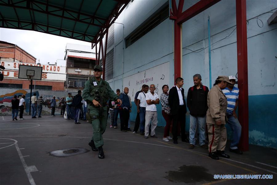 Personas permanecen en fila para emitir su voto durante las elecciones regionales, en un centro de votación en Petare, estado Miranda, Venezuela, el 15 de octubre de 2017. Venezolanos empezaron a concentrarse desde las 6:00 hora local de este domingo en los principales centros de votación habilitados por el Poder Electoral, para elegir a los 23 gobernadores que regirán por los próximos cuatro a?os. (Xinhua/Fausto Torrealba/AVN)