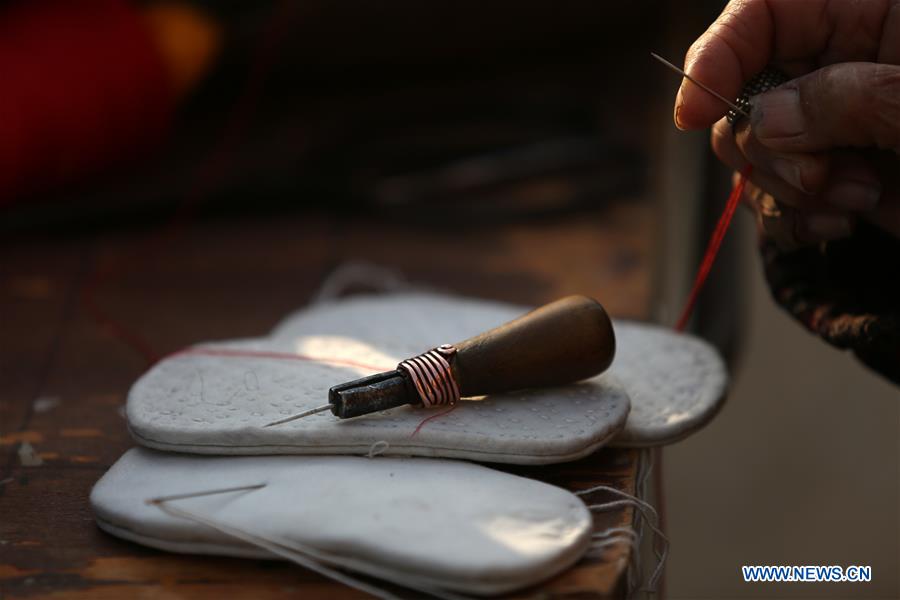 Perdura la antigua tradición de coser zapatos con cabeza de tigre en China