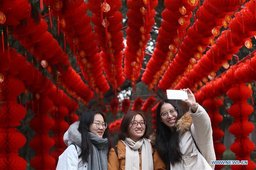 Visitantes disfrutan de la belleza festiva del parque Ditan, conocido también como el parque del Templo de la Tierra. Este lugar ha sido decorado con farolillos rojos para celebrar el próximo Festival de la Primaverao A?o Nuevo Lunar Chino, Beijing, 27 de enero del 2018. [Foto: Xinhua]