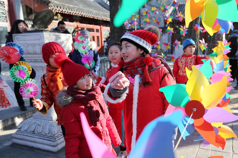 Los ni?os rodeados de molinetes de colores en el Observatorio Antiguo en Beijing para celebrar el periodo del calendario lunar Comienzo de la Primavera, que comenzó el domingo. [Foto de Wang Zhuangfei / chinadaily.com.cn]