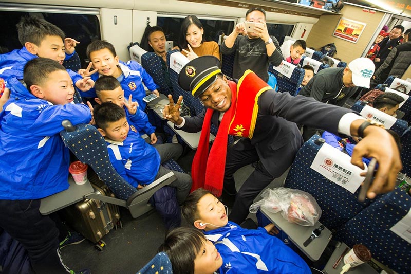 El primer día del Festival de la Primavera del a?o 2018, en el tren Xicheng de alta velocidad D1925, los estudiantes extranjeros voluntarios se hicieron fotos con los pasajeros chinos más jóvenes. Fuente de la imagen: Pueblo en Línea