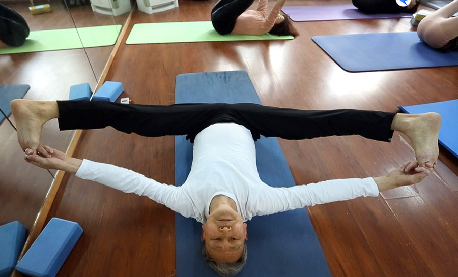 Le Mingchao, un entrenador de yoga de 74 a?os, practica una postura con sus alumnos en Hangzhou, provincia de Zhejiang, el 26 de marzo de 2018. [Foto de WU HUANG / PARA CHINA DAILY]