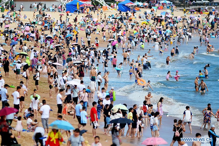 La gente juega en el balneario de Qingdao, E Shandong de China