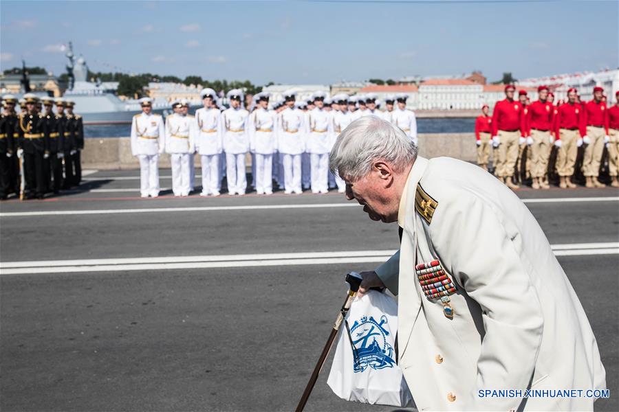 Un veterano de la Armada rusa pasa frente a integrantes de la Armada rusa después del Desfile Naval Principal para conmemorar el Día de la Armada de Rusia, en San Petersburgo, Rusia, el 29 de julio de 2018. El presidente de Rusia, Vladimir Putin, dijo el domingo que Rusia continuará desarrollando sus fuerzas navales y mejorando su equipo. (Xinhua/Wu Zhuang)