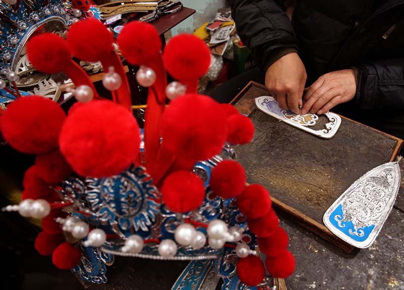 Han Xiaoli, artesano de 55 a?os, necesita tres días mínimo para terminar un sombrero de la ópera Qinqiang hecho totalmente a mano. [Foto: Huo Yan/ Chinadaily.com.cn]