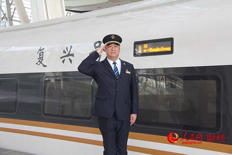 Han Junjia saluda delante del tren de alta velocidad "Fuxing". Por Li Nanhua, Pueblo en Línea.