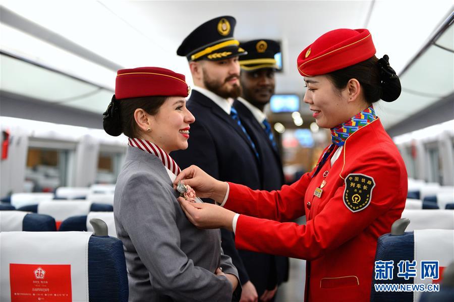 El 20 de enero, en un tren de alta velocidad de la estación ferroviaria Xi'an Norte, una azafata (primera a la derecha) ense?a a los estudiantes voluntarios extranjeros a preparar sus uniformes.