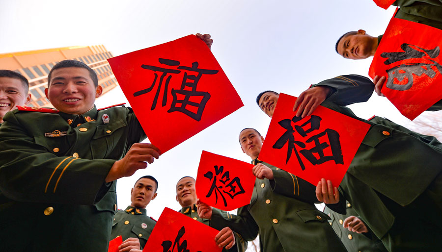 Los soldados muestran su caligrafía con el carácter chino, Fu, que significa buena suerte. [Foto por Hou Chonghui para chinadaily.com.cn]