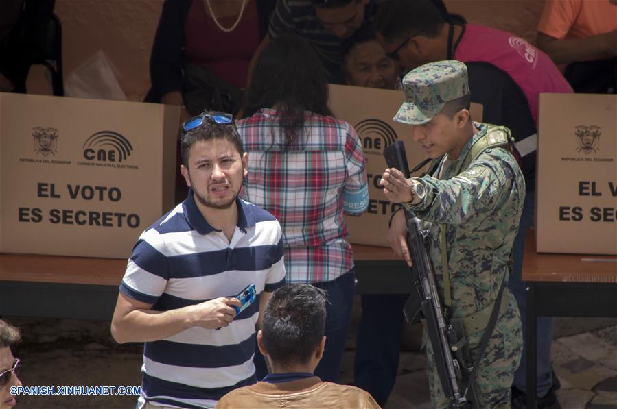 Un soldado da indicaciones a una persona que se presenta en el colegio San Vicente de Paúl para emitir su voto, en Quito, capital de Ecuador, el 24 de marzo de 2019. Los colegios electorales abrieron este domingo a las 07:00 hora local (12:00 GMT) en Ecuador para elegir a autoridades de Gobiernos locales y a los miembros del Consejo de Participación Ciudadana y Control Social (CPCCS). (Xinhua/Santiago Armas)