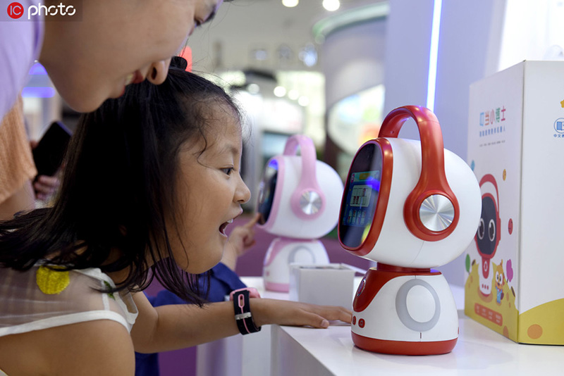 Una ni?a interactúa con un robot en la Expo Central China 2019 en Nanchang, provincia de Jiangxi, el 19 de mayo del 2019. [Foto: IC]