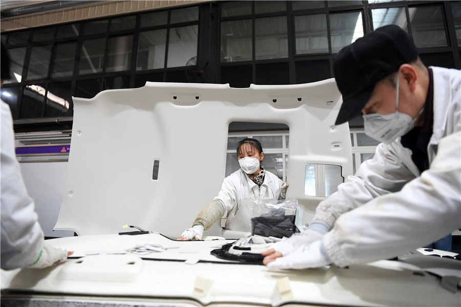 Empleados trabajan en el taller de Faurecia Automotive Parts, empresa chino-francesa, ubicada en el área de desarrollo del aeropuerto de Chongqing, 12 de febrero del 2020. [Foto: Xinhua]