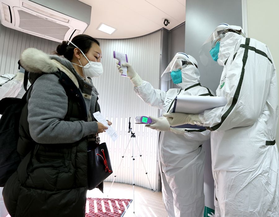 Personal de aduana toma la temperatura corporal de una pasajera en el Aeropuerto Internacional Capital de Beijing, capital de China, el 7 de marzo de 2020. Las aduanas de todo el país vienen vigilando de cerca la epidemia tanto a nivel nacional como internacional. (Xinhua/Chen Jianli)