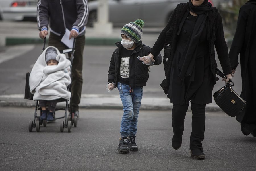 Imagen del 7 de marzo de 2020 de un ni?o usando una mascarilla cruzando una calle, en Teherán, Irán. (Xinhua/Ahmad Halabisaz)